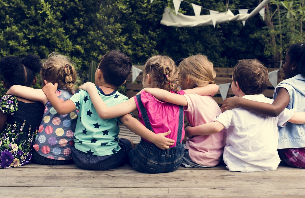 Young children sitting together outdoors